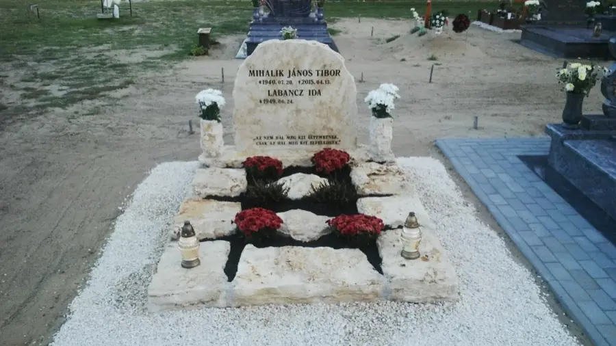 Rusztikus családi dupla mészkő sírkő természetes szikla fejkővel, virágokkal díszítve