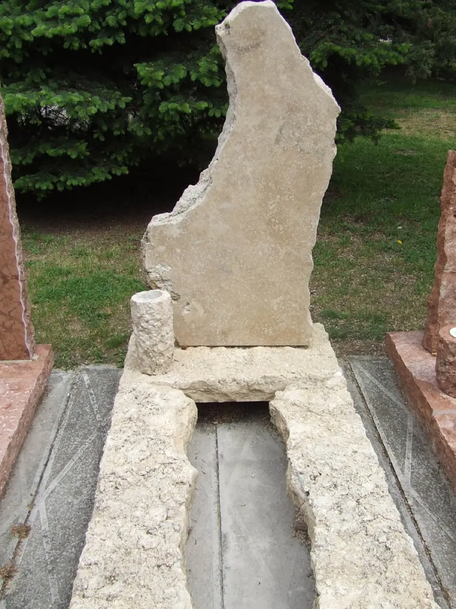 Magas rusztikus mészkő szimpla sírkő természetes formájú fejkővel, kővázával és ágyással