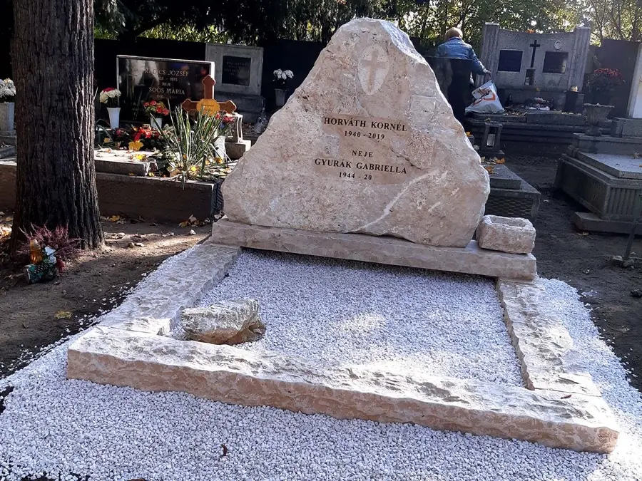 Háromszög alakú rusztikus mészkő páros sírkő két névvel, kavicságyon elhelyezve